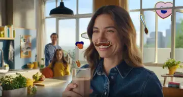 A woman with a glass of milk with Nesquik
